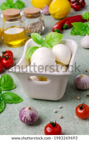 Fresh mozzarella cheese with salad ingredients. Green background. Top view. Selective focus.