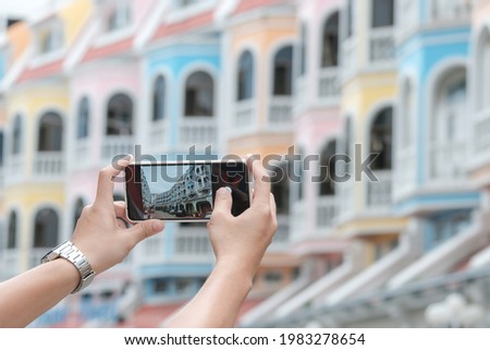 Young people take pictures of the buildings in the city Phuket, thailand. Travel concepts and technology
