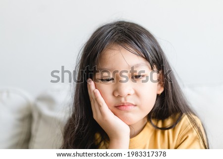 Asian kid girl toothache.kid suffering from toothache.TMD and TMJ healthcare Joint and Muscle Disorder.Asian child hand on cheek face as suffering from facial pain, mumps toothache.Dental health care. Royalty-Free Stock Photo #1983317378