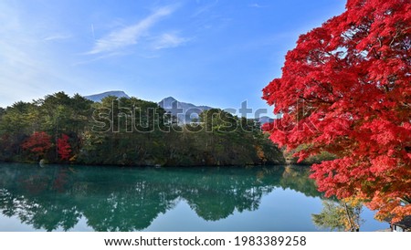 Collaboration scenery of the bright red Maple autumn leaves and Mt. Bandai seen in Bishamonnuma at Goshikinuma, Fukushima