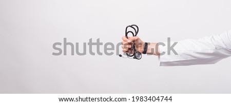 Male doctor hand holding Stethoscope over white background. Royalty-Free Stock Photo #1983404744