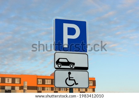 Road parking sign on the background of city orange houses and blue sky