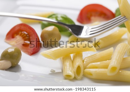 traditional penne pasta with vegetables on the plate