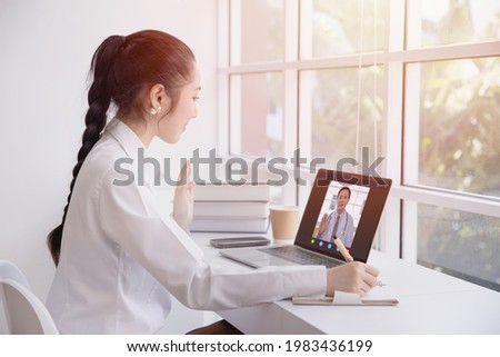 Woman greeting video call with doctor from internet channel staying at home. Girl teen patient in video conferencing with general health practitioner or online personal healthcare for consult. Royalty-Free Stock Photo #1983436199