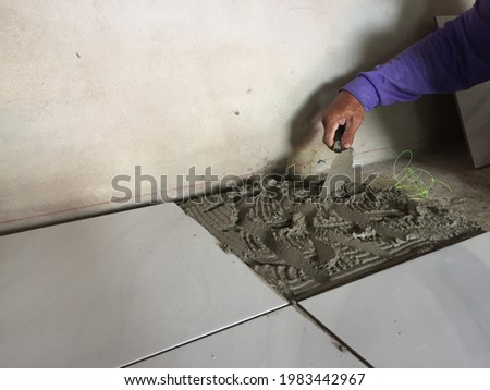Tiles are glued to the floor with glue or cement mortar. That is used notched trowel in the construction of the house floor Office buildings in the interior of the building floor