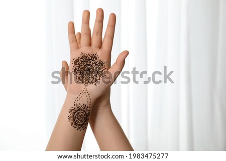 Little girl with henna tattoo on palm, closeup and space for text. Traditional mehndi ornament Royalty-Free Stock Photo #1983475277