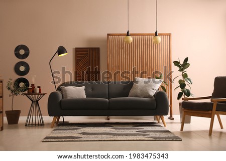 Stylish living room interior with comfortable dark sofa Royalty-Free Stock Photo #1983475343