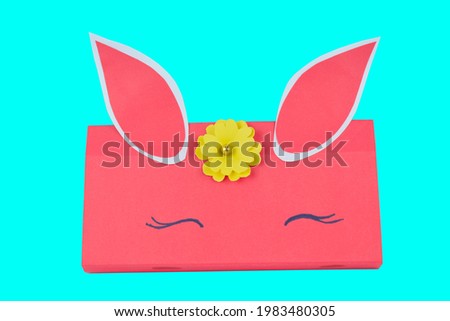 A pink colored hand made paper crafted pencil box placed on a isolated background