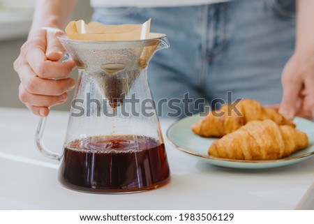 coffee in the morning, European woman brews coffee and drinks it, croissants and coffee for breakfast, internet detox for caucasian woman. black coffee Americano or espresso the perfect start to the