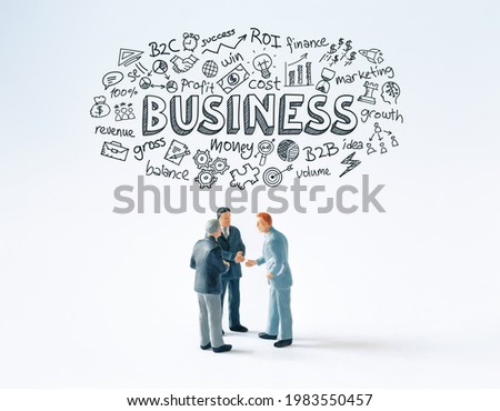 Developing a business strategy concept: Three business people figurines making a deal or talking about a project while hand drawn conceptual doodles and Business text above them. 