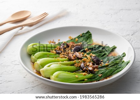Baby Bok choy or chinese cabbage in oyster sauce with Shitake Mushrooms and fried garlic. Royalty-Free Stock Photo #1983565286