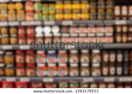 Blurred supermarket aisle with colorful shelves of merchandise