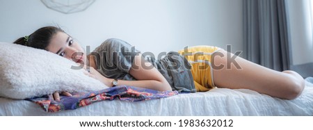 a young caucasian lady enjoy the moment on the bed, relaxing and fully rested smiling girl, sunrise sunshine wake up on the morning.