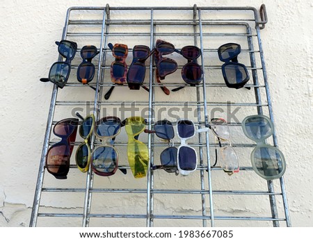 photo of a group of sunglasses hanging from a metal frame