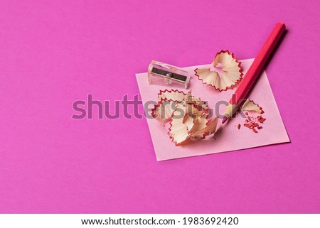 magenta background with colored pencil shavings and sharpener. Preparing pencils for creativity