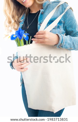 A young girl poses on a white background holding a bag.Studio concept.