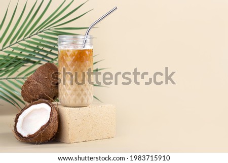 Still life iced americano with coconut milk in a highball and a metal tube on a stone, beige background Royalty-Free Stock Photo #1983715910