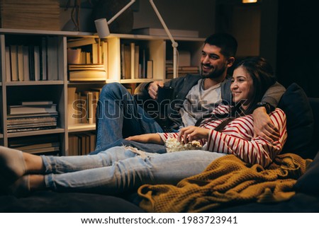 couple enjoying evening at home, watching television