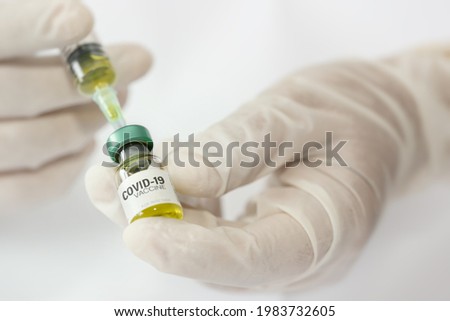 Doctor, nurse, scientist hand wears medical glove holding syringe and vial bottle with COVID-19 coronavirus vaccine for injections.Vaccine against COVID-19 coronavirus,Healthcare And Medical concept.
