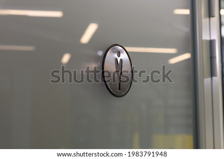 round sign men's toilet on the door