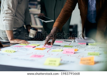 Close-up of creative people working on new business project and analyzing mind map on paperboard.  Royalty-Free Stock Photo #1983795668