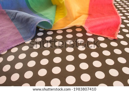 Flag with the colors of the rainbow on a polka dot background. Free space to write.