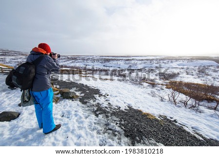 photographer taking a picture in a snow-covered landscape