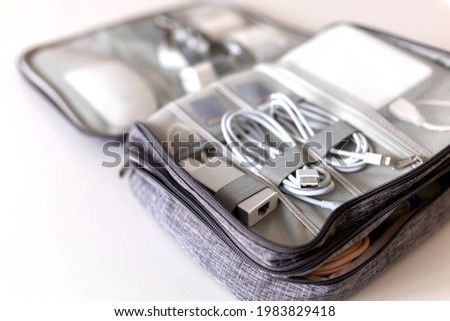 Closeup modern comfortable storage case for wires, tablet, technique, equipment, charge, memory card and earphones. Contemporary electronic device and tools at save package for travel or trip Royalty-Free Stock Photo #1983829418