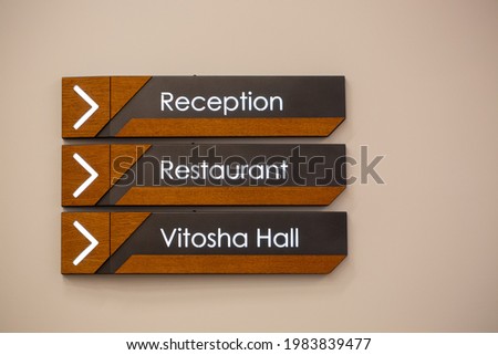 A closeup of the hotel sign plates: "Reception", "Garage", and "Vitosha Hall"