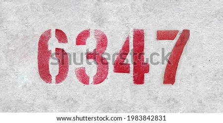Red Number 6347 on the white wall. Spray paint.