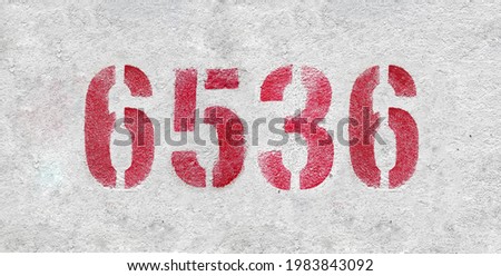 Red Number 6536 on the white wall. Spray paint.