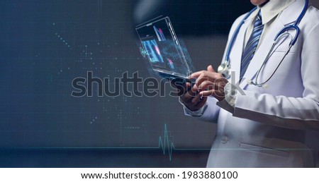 Woman doctor holding smart device with holographic, futuristic head up display on smart device for medical examination and medical diagnosis Royalty-Free Stock Photo #1983880100