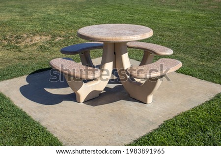 A heavy duty round picnic table at a park.