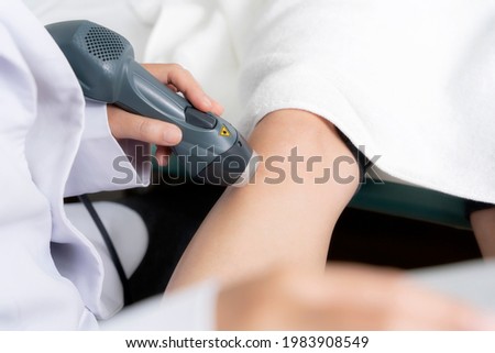 Close up, Orthopedist doctor doing laser ultrasound examination of patient's knee in his clinic. Medical and healthcare concept , Image with a soft focus, Copy space