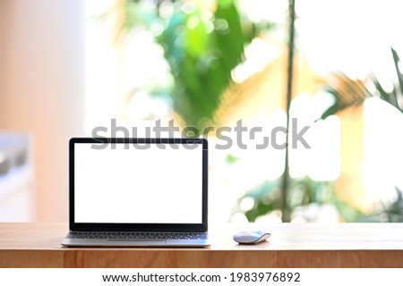 Laptop computer with blank screen in garden house