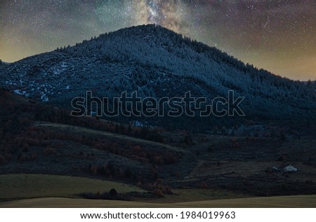 A superb shot of colorful Milky Way glowing in the sky seen through snow-covered mountain