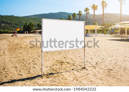 Empty white advertising billboard with mock up place stands on sandy beach at summer day