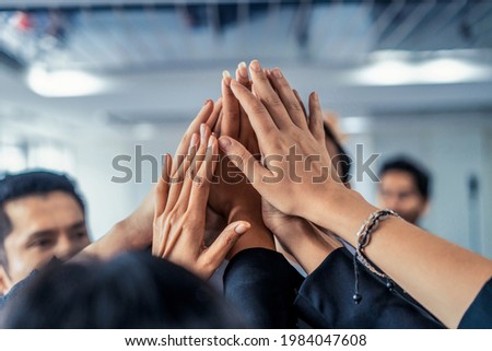 Many happy business people raise hands together with joy and success. Company employee celebrate after finishing successful work project. Corporate partnership and achievement concept. Royalty-Free Stock Photo #1984047608