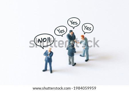 Conflict or discussion in business world concept: Three like-minded business people figurine saying yes while the opposing businessman arms crossed saying No on white background.  Royalty-Free Stock Photo #1984059959