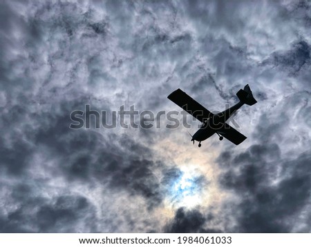 Light aircraft against a cloudy sky and a halo