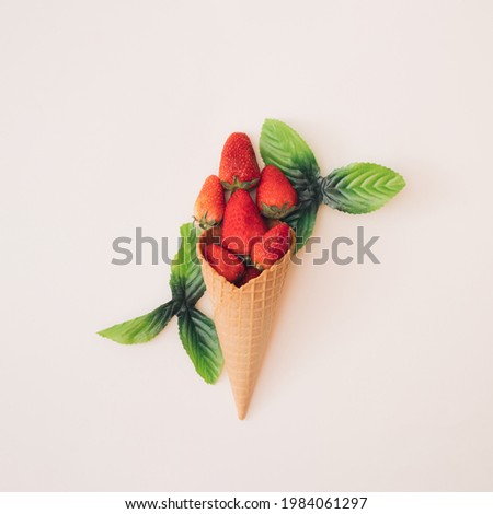 Strawberries in a brown cone with green leaves.