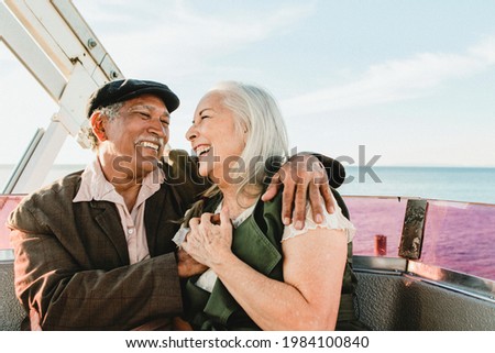 Cheerful senior couple enjoying a Ferris wheel by the Santa Monica pier Royalty-Free Stock Photo #1984100840