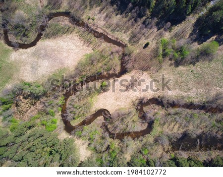 An aerial shot of a beautful winding river flowing through fields