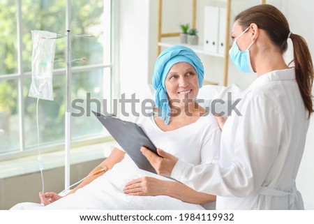 Doctor telling good news to mature woman after chemotherapy in clinic Royalty-Free Stock Photo #1984119932