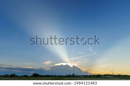 Twilight blue bright and orange with sunbeams shining through dramatic white clouds sunset sky in countryside or beach colorful cloudscape texture air background.