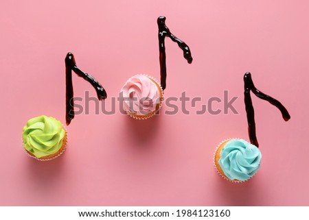 Music notes made of cupcakes on color background