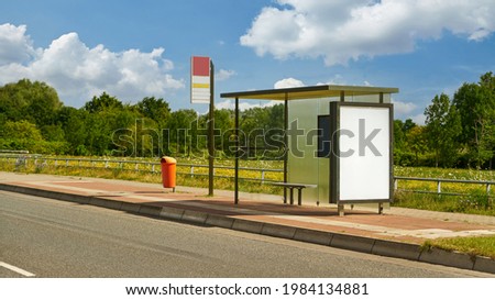Empty bus stop with bus shelter and advertising poster template mock-up in summer Royalty-Free Stock Photo #1984134881