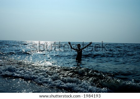 Silhouette of boy playing on waves in sea