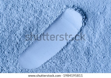 Light blue bentonite facial clay powder (alginate mask, body wrap) texture close up, selective focus. Abstract background with brush stroke.  Royalty-Free Stock Photo #1984195811