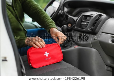 Man with first aid kit in car Royalty-Free Stock Photo #1984226198